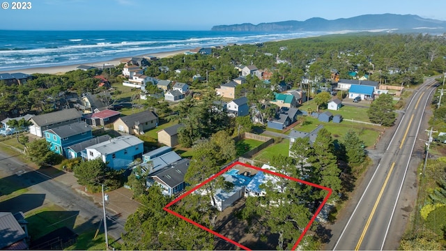 drone / aerial view featuring a beach view and a water and mountain view