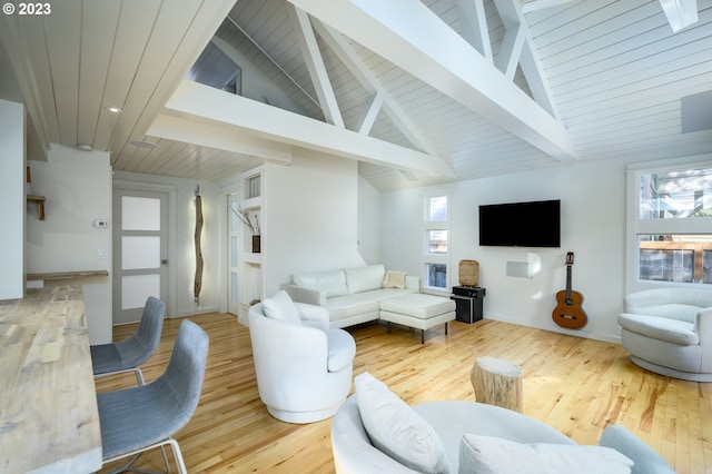 living room featuring beamed ceiling, a healthy amount of sunlight, wood-type flooring, and wooden ceiling