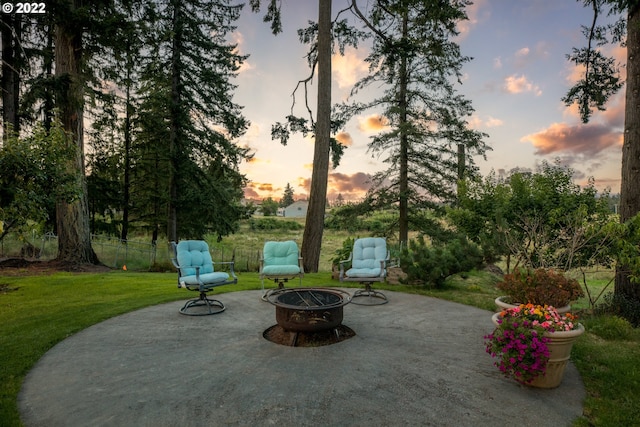 patio terrace at dusk with an outdoor fire pit and a yard