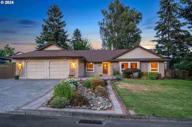 ranch-style home with a garage and a lawn