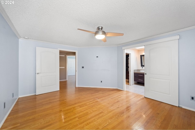 interior space featuring ensuite bathroom, light hardwood / wood-style floors, a textured ceiling, and ornamental molding