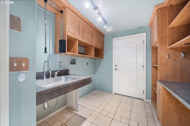 kitchen featuring rail lighting, light tile patterned floors, and sink