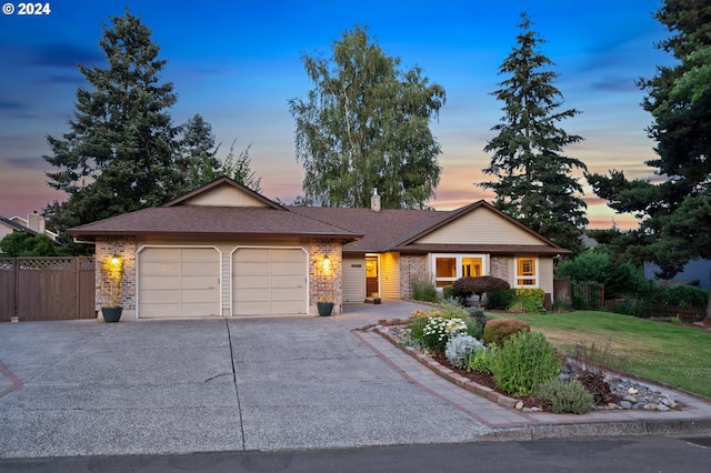 ranch-style home featuring a lawn and a garage