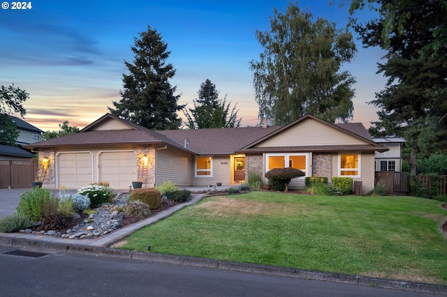 ranch-style house with a yard and a garage