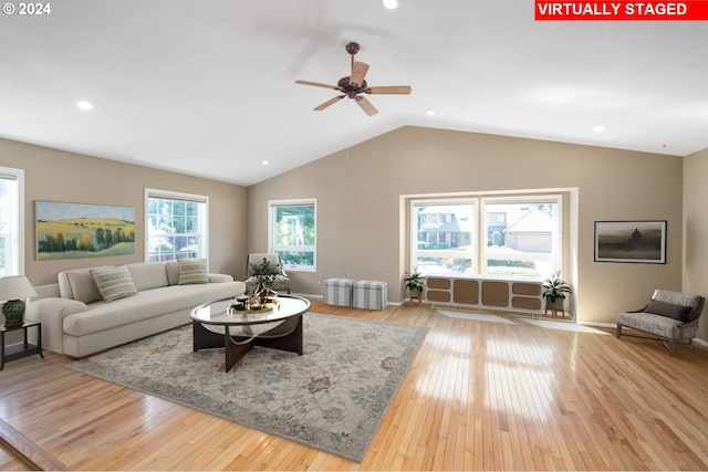 living room featuring light hardwood / wood-style flooring, ceiling fan, and lofted ceiling