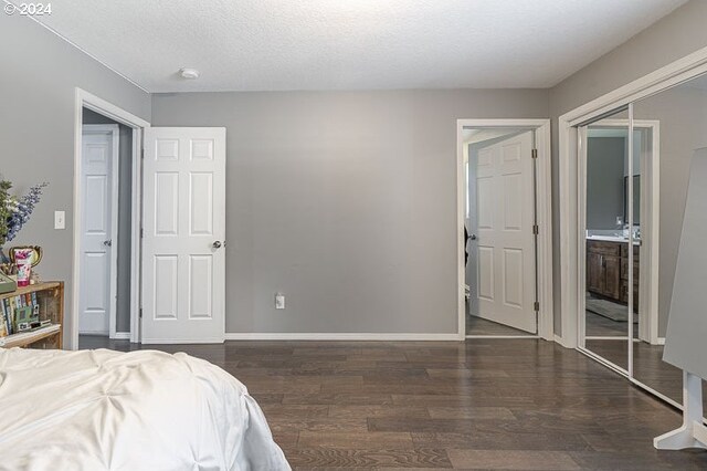 bedroom featuring a textured ceiling, a closet, and dark wood-type flooring