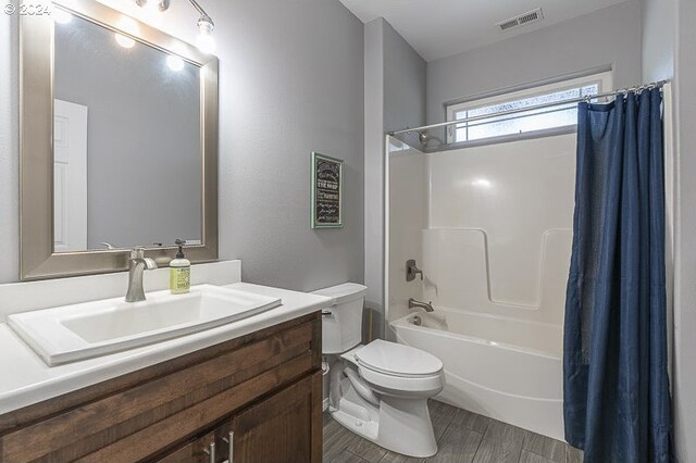 full bathroom with vanity, hardwood / wood-style floors, toilet, and shower / bath combo