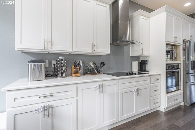 kitchen featuring white cabinets, stainless steel appliances, wall chimney exhaust hood, and dark hardwood / wood-style floors