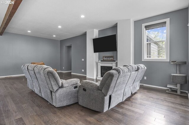 living room featuring beam ceiling and dark hardwood / wood-style floors