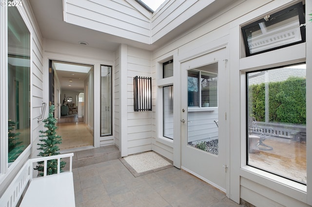 entryway featuring light tile patterned floors and wooden walls