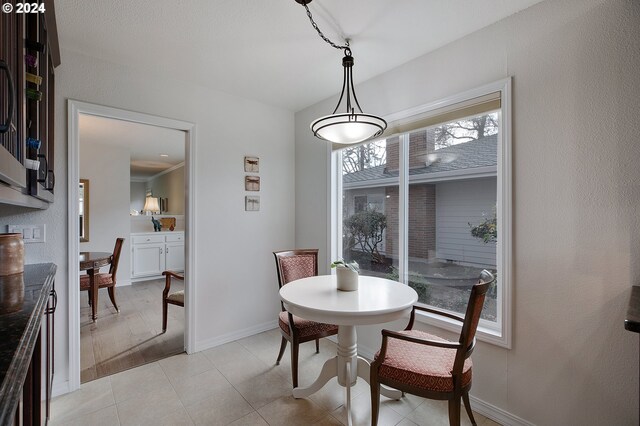 dining space with crown molding and light tile patterned flooring