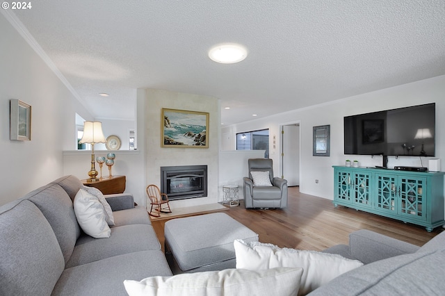 living room featuring ornamental molding, hardwood / wood-style flooring, and a textured ceiling