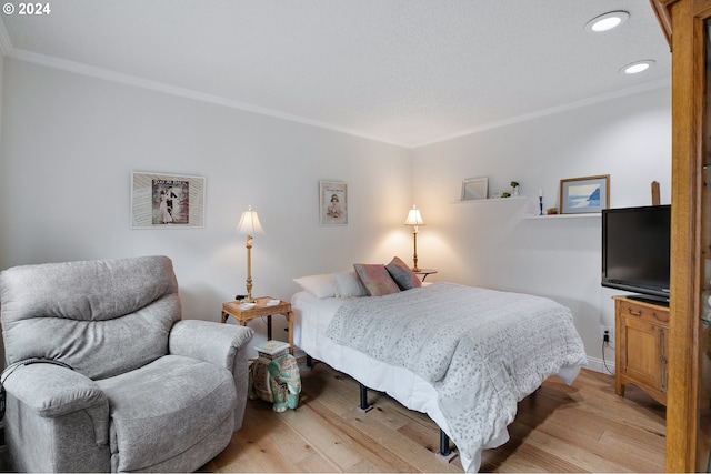 bedroom with crown molding and light hardwood / wood-style floors