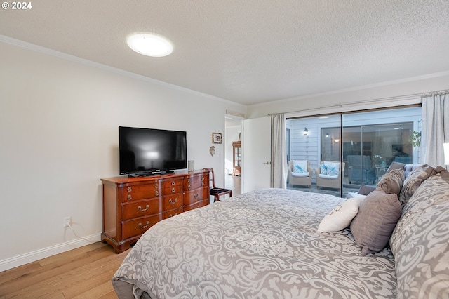 bedroom with light hardwood / wood-style floors, crown molding, a textured ceiling, and access to exterior