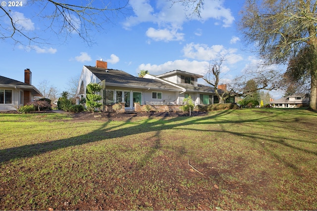 back of property featuring a lawn