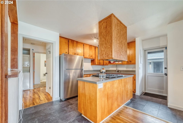 kitchen with stainless steel appliances, a kitchen island, and dark wood-type flooring