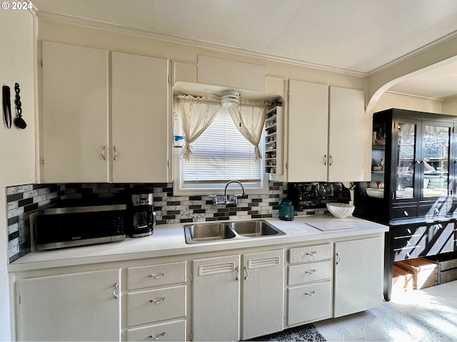 kitchen with tasteful backsplash, sink, and white cabinets