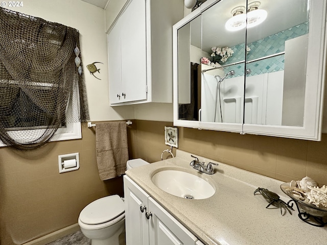 bathroom featuring vanity, toilet, and a shower