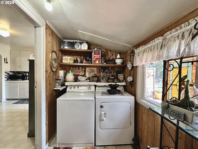 laundry room with independent washer and dryer and wood walls