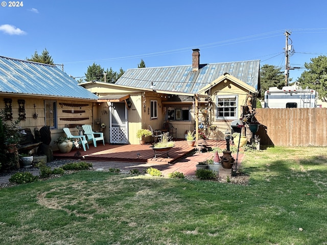 rear view of property featuring a deck and a lawn