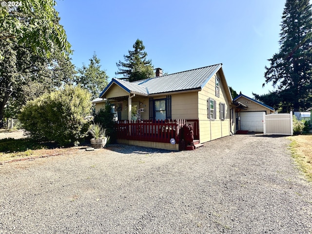 exterior space with an outdoor structure, a garage, and a porch