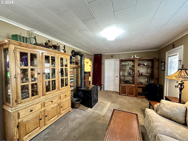 living room with light colored carpet, ornamental molding, and a wood stove