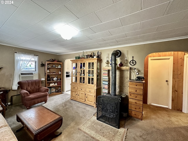 living room with cooling unit, crown molding, carpet floors, and a wood stove