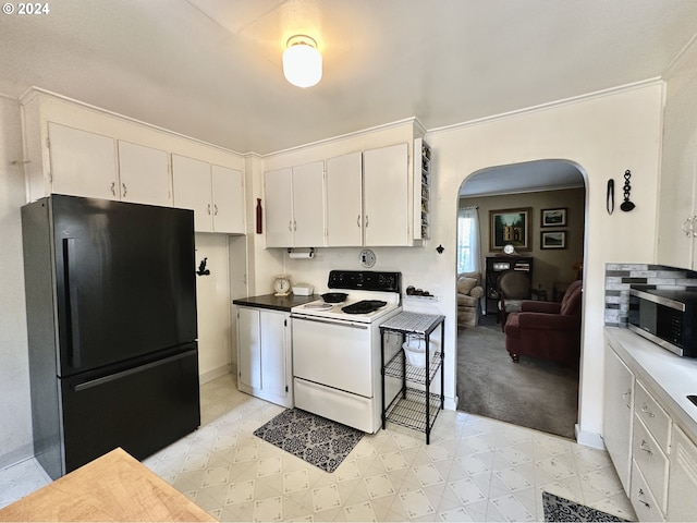 kitchen with ornamental molding, black refrigerator, white cabinets, and white range with electric cooktop