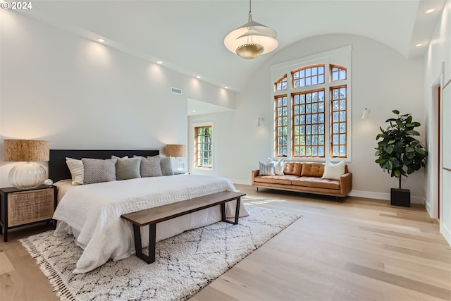 bedroom featuring light hardwood / wood-style floors and high vaulted ceiling