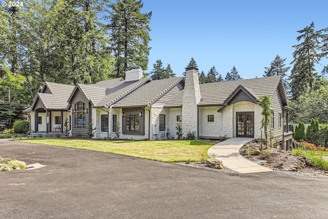 view of front of house with french doors and a front lawn