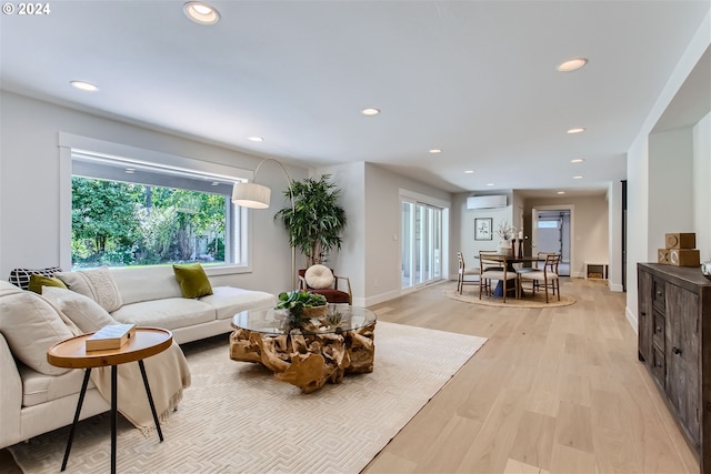 living room featuring a wall unit AC and light hardwood / wood-style floors