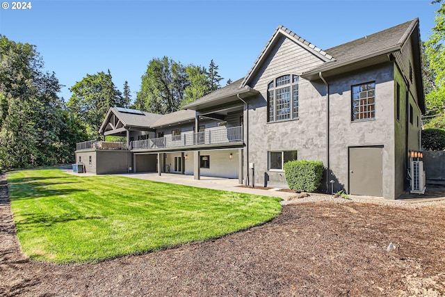 rear view of house featuring a yard, a balcony, and a patio