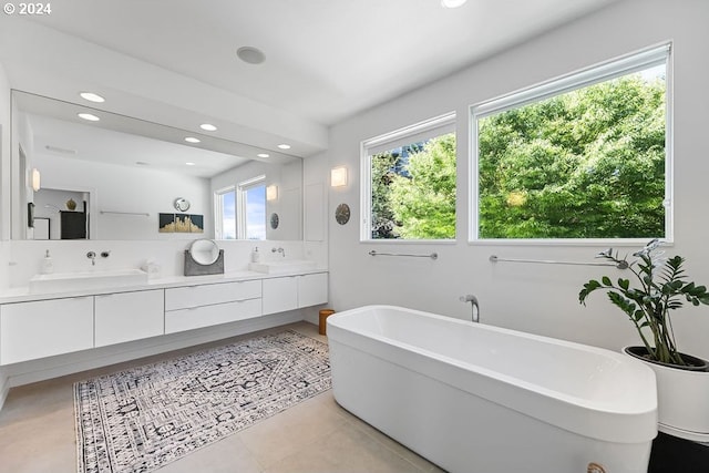 bathroom with tile patterned flooring, a bathtub, and vanity