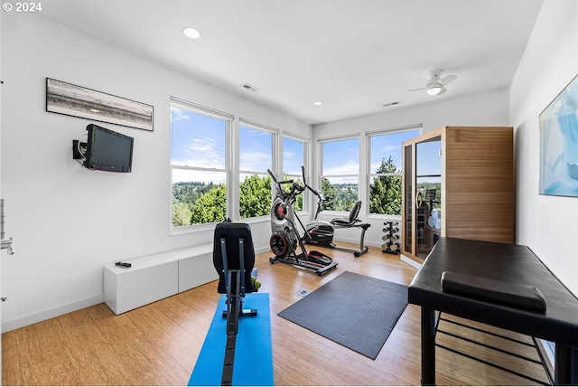 workout area with light wood-type flooring and ceiling fan