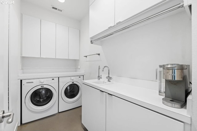 laundry room with cabinets, washer and dryer, and sink