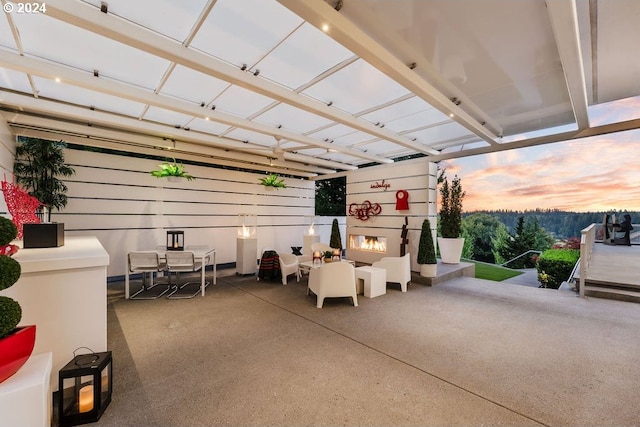 patio terrace at dusk featuring an outdoor fireplace