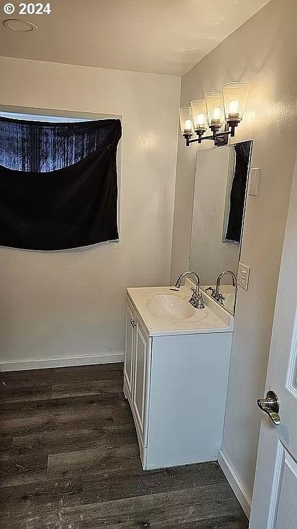 43460 Nicholson Dr, Port Orford, OR 97465 - bathroom featuring a chandelier, vanity, wood finished floors, and baseboards