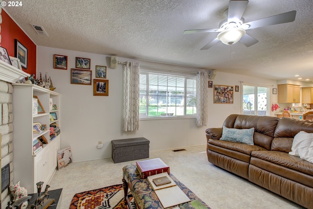 carpeted living room with a textured ceiling and ceiling fan