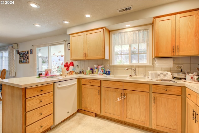 kitchen with kitchen peninsula, a textured ceiling, sink, and dishwasher