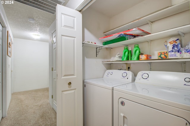 laundry area with a textured ceiling, light carpet, and separate washer and dryer