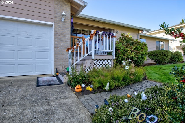 doorway to property with a lawn and a garage