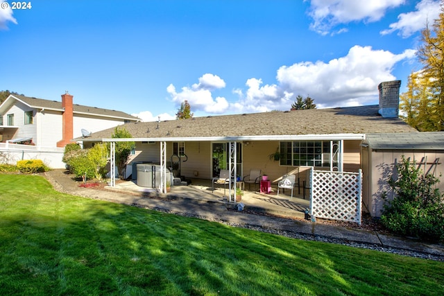 rear view of house with a lawn and a patio area