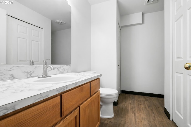 bathroom with hardwood / wood-style flooring, vanity, and toilet