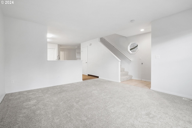 unfurnished living room featuring light carpet