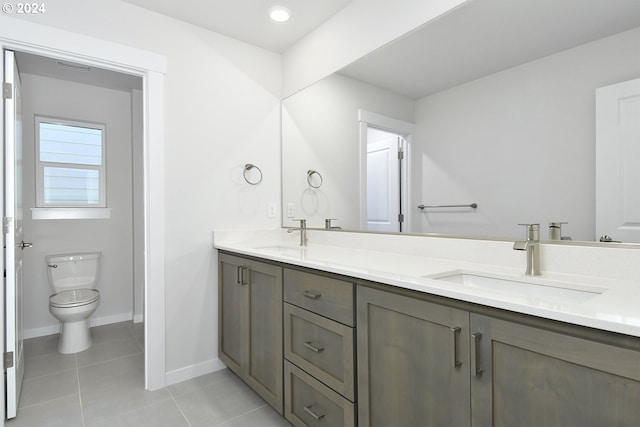 bathroom featuring tile floors, toilet, and double sink vanity