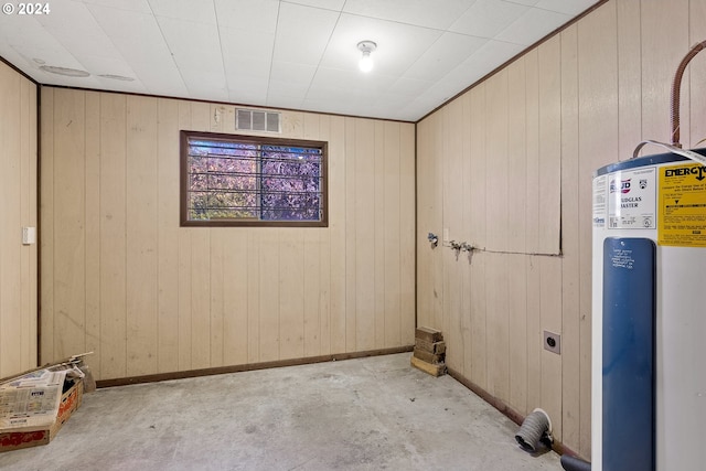 basement with water heater and wooden walls