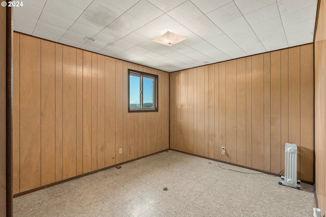 unfurnished room with light floors and wooden walls