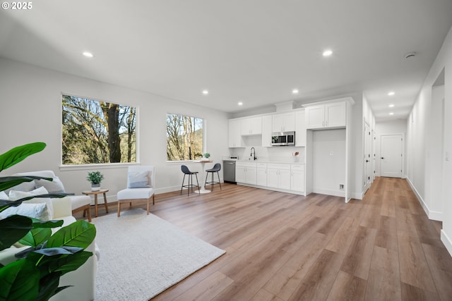 sitting room featuring sink and light wood-type flooring