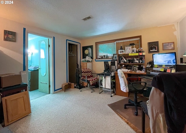 carpeted office space featuring a textured ceiling