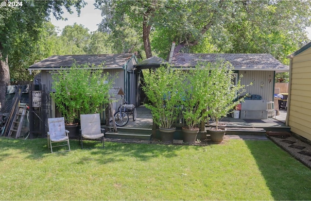 rear view of property with a lawn, a shed, and a wooden deck